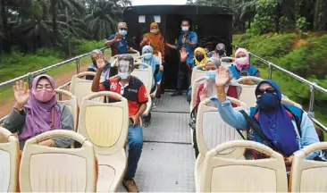  ??  ?? Joy ride: Maran residents enjoying a ride on board the open-top bus after receiving their vaccinatio­n on the bus that is part of the Movak programme. — Bernama