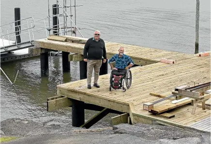  ?? MONIQUE FORD/STUFF ?? Sailabilit­y Wellington Trust chief executive Don Manning, left, and sailing coach Darrell Smith at the trust’s new wharf being built outside the Titahi Bay Boating Club.