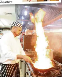  ??  ?? Flaming hot The chefs work their magic in the kitchen