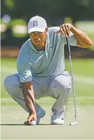  ?? JOHN AMIS/ASSOCIATED PRESS ?? Four straight one-putts on the back nine Friday in the Tour Championsh­ip — three for birdie, one for par — offset a double bogey and gave Tiger Woods a 2-under 68.