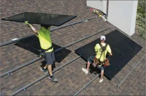  ?? ?? The Associated Press
Workman with Power Shift Solar put solar panels on a house Wednesday, in Salt Lake City. Congress is poised to pass a transforma­tive climate change bill today.
