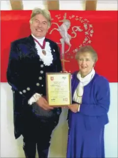  ??  ?? Molly Poulter of Ulcombe receives a Kent Associatio­n of Local Communitie­s Award from George Jessel, the High Sheriff of Kent for her hard work in the village