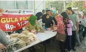  ?? FIRMA ZUHDI/JAWA POS ?? STABILKAN HARGA: Warga antre membeli gula murah di Pasar Tani yang berlangsun­g di halaman depan kantor dispaperta kemarin.