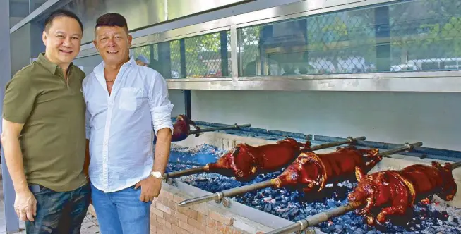 ??  ?? Now roasting: Rico’s Lechon owner and Meat Concepts Corp. president George Pua and Rico’s Lechon creator Rico Dionson
