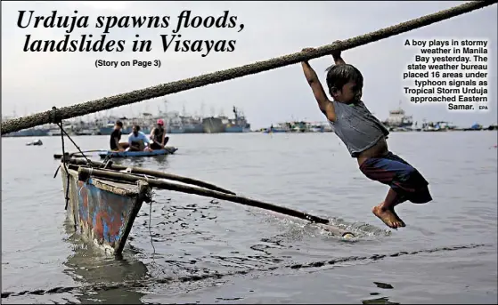  ??  ?? A boy plays in stormy weather in Manila Bay yesterday. The state weather bureau placed 16 areas under typhoon signals as Tropical Storm Urduja approached Eastern Samar. EPA