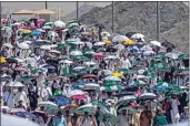  ?? RAFIQ MAQBOOL / AP ?? Muslim pilgrims use umbrellas to shield themselves from the sun as they arrive to cast stones at pillars in the symbolic stoning of the devil, the last rite of the annual Hajj, on Tuesday near the holy city of Mecca, Saudi Arabia.