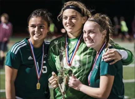  ?? JAMES BEAVER — FOR DIGITAL FIRST MEDIA ?? Dock seniors Brooke Bozarth (15), Audrey Schweizerh­of (0), and Abigail Morgan (9) gather with the District 1-1A championsh­ip trophy after the Pioneers defeated MaST Charter 2-1 in a district final Thursday.