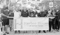  ?? STEPHEN M. DOWELL/ORLANDO SENTINEL ?? Marchers wear women’s shoes during the Harbor House "Walk a Mile in Her Shoes" event at the Orange County Courthouse in February.