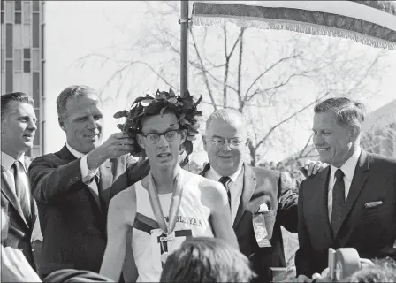  ?? AP FILE PHOTO ?? Ambrose “Amby” Burfoot, center, a Wesleyan University senior from Groton, receives a laurel wreath from Boston’s Mayor Kevin White after winning the 72nd annual Boston Athletic Associatio­n Marathon, April 20, 1968. Race Director Will Cloney, far right,...