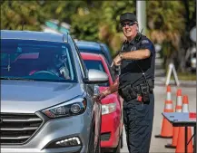  ?? GREG LOVETT / THE PALM BEACH POST ?? School police officer Andrew Rundle directs traffic into Forest Hill High School for its game against Suncoast on Thursday in West Palm Beach.