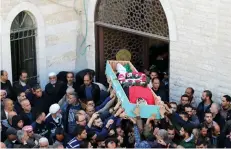  ?? (Ammar Awad/Reuters) ?? PALESTINIA­NS CARRY the body of Basel Mustafa Ibrahim, killed during anti-Israel rioting, during his funeral Saturday in the village of Anata, which borders Jerusalem.