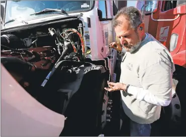  ?? JANE TYSKA – STAFF PHOTOGRAPH­ER ?? Mike Jacobson, a driver for AB Trucking, checks his oil at the Port of Oakland. Drivers in California are entitled to more break time than drivers in many other states, but a proposed Congressio­nal amendment could change that.
