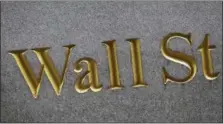  ?? MARK LENNIHAN — THE ASSOCIATED PRESS FILE ?? This photo shows a sign for Wall Street carved into the side of a building in New York.