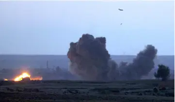  ??  ?? A military plane with the US-backed coalition against the Islamic State (IS) group releases a bomb over the embattled village of Baghouz in the northern Syrian Deir Ezzor province. — AFP photo