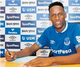  ?? FOTO EVERTON ?? Yerry Mina firmando el contrato que lo vincula por cinco temporadas al Everton.