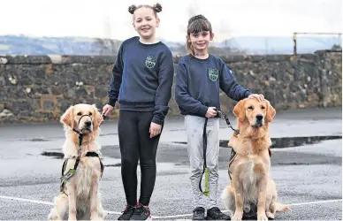  ?? ?? Friends forever
Ciara Burns and Isla Gill are pictured with new pals, training guide dog puppies Bailey and Bess