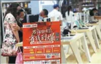  ?? SONG NING / FOR CHINA DAILY ?? Above: Customers buy electronic products at a Suning store in Nanjing, capital of Jiangsu province, on June 17.