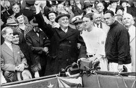  ?? FILE — THE ASSOCIATED PRESS ?? President Franklin D. Roosevelt prepares to throw out the ceremonial first pitch at Griffith Stadium in Washington before Game 3of the 1933 World Series, the last one in Washington before this year. Washington Senators manager Joe Cronin, third from right, and New York Giants manager Bill Terry, second from right, look on. The President uncorked an almost wild throw that sent the players scrambling.