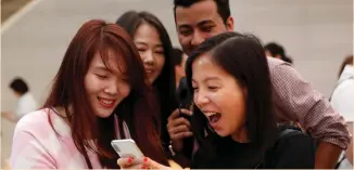  ??  ?? PEOPLE LOOK at the iPhone X during its launch at the Apple store in Singapore in November.