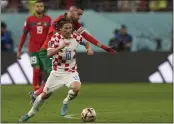  ?? FRANK AUGSTEIN — THE ASSOCIATED PRESS ?? Croatia's Luka Modric, front, duels for the ball with Morocco's Hakim Ziyech during the World Cup third-place playoff soccer match between Croatia and Morocco at Khalifa Internatio­nal Stadium in Doha, Qatar, Saturday.