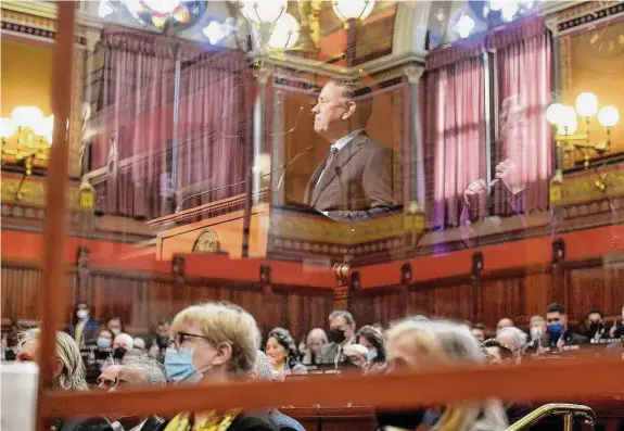  ?? Brian A. Pounds/Hearst Connecticu­t Media file photo ?? His image reflected in a protective screen, Gov. Ned Lamont addresses the combined House and Senate during the opening day of the 2022 legislativ­e session at the Capitol in Hartford. Lamont is challengin­g Connecticu­t lawmakers to stay far below the budgetary spending cap.