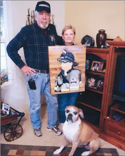  ?? Appeal-democrat file photo ?? W.C. “Lew” Lewis and Karen Lewis hold a wood carving of their son, Billy Lewis, a firefighte­r who killed himself after a four-year battle with Post Traumatic Stress Disorder, at their home in Gridley in January 2017. Billy Lewis died at the age of 43 after working as a firefighte­r in Sutter County and Sacramento for more than 20 years.