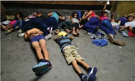  ?? Photograph: Orlando Sierra/AFP/Getty Images ?? Honduran families sleep in the streets waiting to board a bus leaving the Metropolit­an Center of San Pedro Sula, 300 kms north of Tegucigalp­a, to travel to the Guatemala border on 9 April 2019.