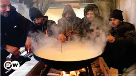  ??  ?? Migranten kochen am 8.01.2021 in einem selbstgeba­utem provisoris­chen Unterschlu­pf nahe des abgebrannt­en Camps "Lipa"