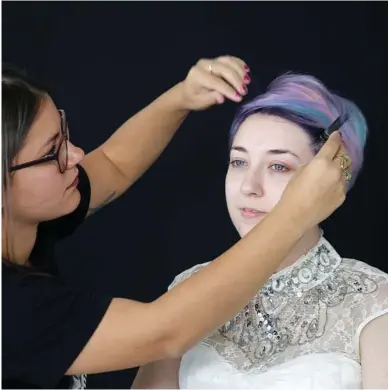  ?? Kirk McKoy / Los Angeles Times ?? Makeup artist Amber Talarico pins back Kota Wade’s hair during a Facebook Live video of an episode of “Becoming” from online publisher Moviepilot.