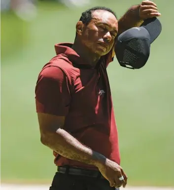  ?? CHARLIE RIEDEL/AP ?? Tiger Woods wipes his face on the 16th hole during the final round at the Masters on Sunday at Augusta National Golf Club in Georgia.