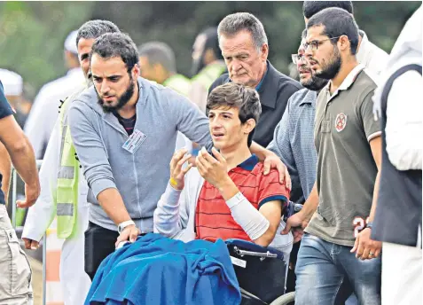  ??  ?? Zaed Mustafa, 13, who survived the terrorist attack in New Zealand last week, at the funeral of his brother, Hamza, and father, Khalid, at Memorial Park Cemetery