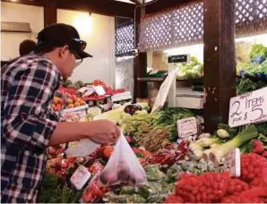  ??  ?? Buying fresh fruits and vegetables at the Fremantle market.