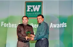  ??  ?? Minister of Plantation Industries, Navin Dissanayak­e presenting an award to Managing Director of Kelani Valley Plantation­s and Talawakell­e Tea Estates, Roshan Rajadurai