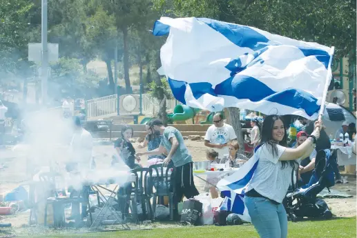  ?? (Marc Israel Sellem/The Jerusalem Post) ?? PEOPLE CELEBRATE independen­ce day with flags and barbecue in Jerusalem’s Sacher Park yesterday.