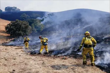  ?? JIM WILSON / NEW YORK TIMES ?? Firefighte­rs take advantage of light winds Wednesday to contain a wildfire on a ranch in Bennett Valley, which is in California’s Sonoma County. Nearly two dozen wildfires are burning in Northern California, and have affected 170,000 acres — an area larger than the city of Chicago.