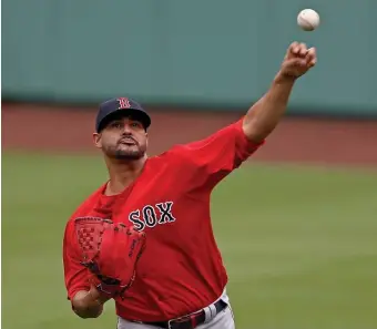  ??  ?? LONG ROAD BACK: Martin Perez throws in the outfield as the Red Sox opened summer camp on Friday.