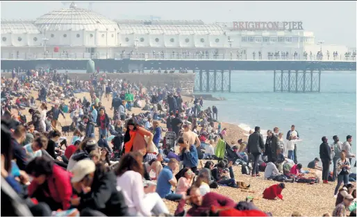  ?? Picture: STEVE REIGATE ?? Hardly a spare space to sit down... crowds in Brighton yesterday as temperatur­es almost hit 70F