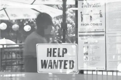  ?? FREDERIC J. BROWN/GETTY-AFP ?? A“help wanted”sign is posted beside COVID-19 safety guidelines last month at a Los Angeles restaurant.