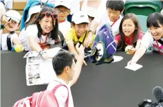  ?? — AFP photo ?? Kei Nishikori throws his towel towards young fans as he leaves the court after beating Ernests Gulbis.