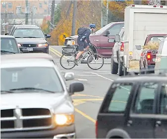  ?? DARREN STONE, TC ?? A cyclist rides through traffic at the intersecti­on of Quadra and Finlayson streets. A tragic crash could be avoided by cyclists and drivers being more aware of each other, Steve Wallace writes.