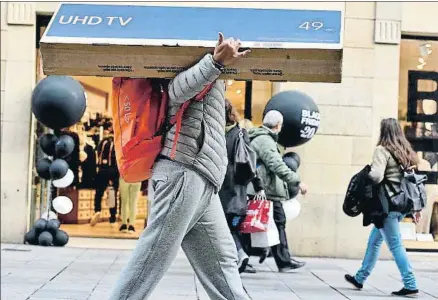  ?? ÀLEX GARCIA ?? Uno de los muchos barcelones­es que aprovechar­on la jornada de ofertas para redecorar el salón de su casa