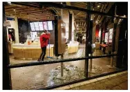  ?? PETER DEJONG / AP ?? A man cleans up glass from the smashed windows in a restaurant damaged in protests against a curfew in Rotterdam, Netherland­s, on Monday.