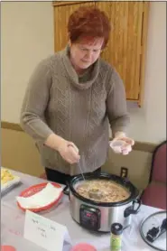  ?? LAUREN HALLIGAN — DIGITAL FIRST MEDIA ?? Pam Greenberg of Brunswick serves a creamy tequila lime jerk chicken chili sample at the 2019 Brunswick Elks Lodge Chili Challenge.