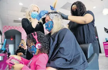  ?? AMY BETH BENNETT/SOUTH FLORIDA SUN SENTINEL PHOTOS ?? Top: Salon owner and stylist Diane Zahuranec and stylist Dominique Torres work on customer Melissa Turi while she holds 4-year-old daughter Layla on Monday at the Hello Beautiful Salon in Fort Lauderdale.