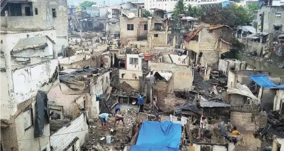  ?? ROWENA CAPISTRANO AND JAYPEE LAO ?? The aftermath of the fire that razed 284 houses and left 636 families homeless in Barangay Pasil, Cebu City. (Top photo) Mayor Tomas Osmeña visits the fire-stricken area to personally assess the situation before the rebuilding.