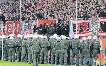  ?? FOTO: IMAGO ?? Polizisten sichern das Fußballfel­d bei einem Spiel von Rot-Weiss Essen gegen den MSV Duisburg. Die eskalieren­de Gewalt macht vor allem auch Fans Sorgen, die friedlich Spiele besuchen wollen.