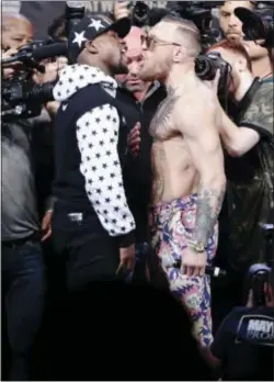  ?? FRANK FRANKLIN II — THE ASSOCIATED PRSS ?? Conor McGregor, right, reacts as Floyd Mayweather Jr., left, jaws during a news conference at Barclays Center on Thursday in New York.