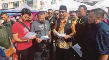  ??  ?? DR Abdul Rahman (tiga dari kanan) bersama Zulkefkly (dua dari kanan) mengedarka­n risalah mengenai kesan dan bahaya budaya LGBT di Pasar Tani UTC Kuantan.