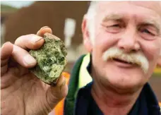  ??  ?? Mt Shadwell Quarry supervisor Keith Hargreaves with a chunk of peridot, a semi-precious stone unearthed from the olivine deposits in the quarry on the outskirts of Mortlake.