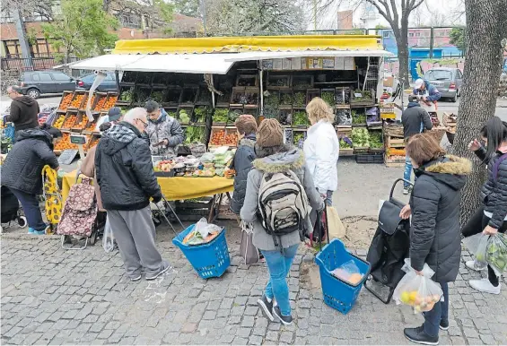  ?? LUCIANO THIEBERGER ?? En busca del ahorro. Pese al frío, anteayer, vecinos hacen cola con sus carritos frente a los puestos instalados en la Plaza Mafalda.